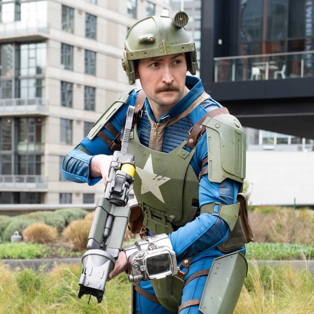 Cosplayer wearing custom 3D printed armor and helmet, holding a prop weapon